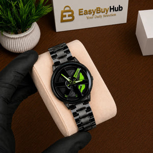 A black round analog watch with a matching black metal link bracelet and a bright neon green dial detail, held by a hand wearing a black glove on a beige display cushion. A wooden table surface, a small potted plant, and a branded EasyBuyHub box are visible in the background.