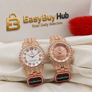 Two luxury-style wristwatches displayed side by side on draped white fabric, with a branded EasyBuyHub backdrop and red decorative pom detail. The watches have rose-gold-toned metal cases and bracelets, crystal-encrusted bezels, and white and pink-toned dials.